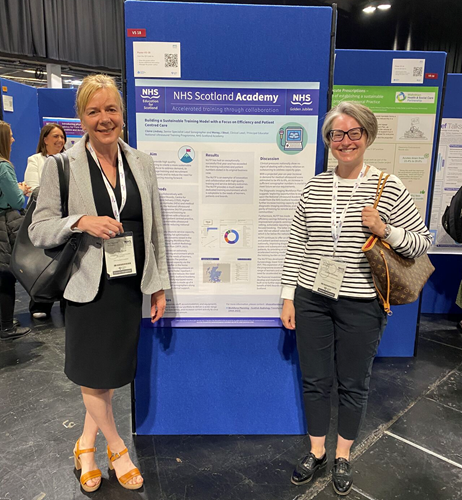 Two people stand in front of a poster